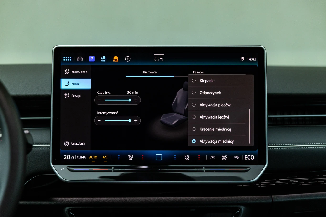 W ID.7 można korzystać z bogatego zestawu programów masażu Centralny ekran dotykowy w samochodzie z wyświetlonym menu sterowania masażem fotela, gdzie widoczne są opcje dotyczące aktywacji różnych stref masażu takich jak plecy, lędźwie czy miednica, a także możliwość dostosowania czasu i intensywności masażu.