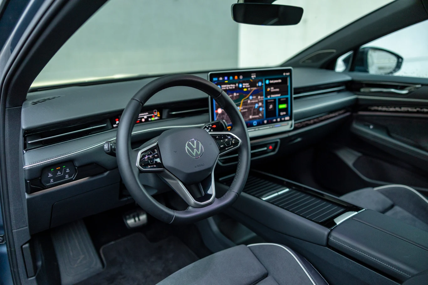 Kokpit jest sensownie rozplanowany, a system multimedialny - łatwy w obsłudze Nowoczesne wnętrze samochodu marki Volkswagen z widocznym cyfrowym kokpitem, dużym dotykowym wyświetlaczem centralnym, wielofunkcyjną kierownicą oraz eleganckimi, minimalistycznymi wykończeniami.