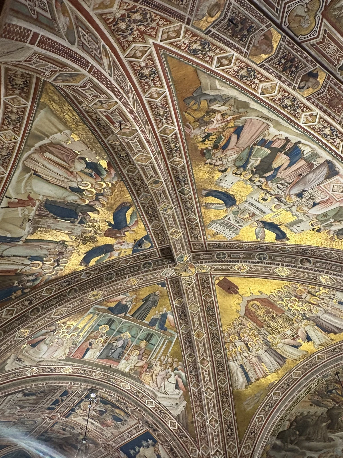 Bogato zdobione sklepienie z freskami prezentującymi sceny religijne z licznymi postaciami w długich szatach, elementami złocenia i misternymi detalami architektonicznymi na tle geometrycznych ornamentów.