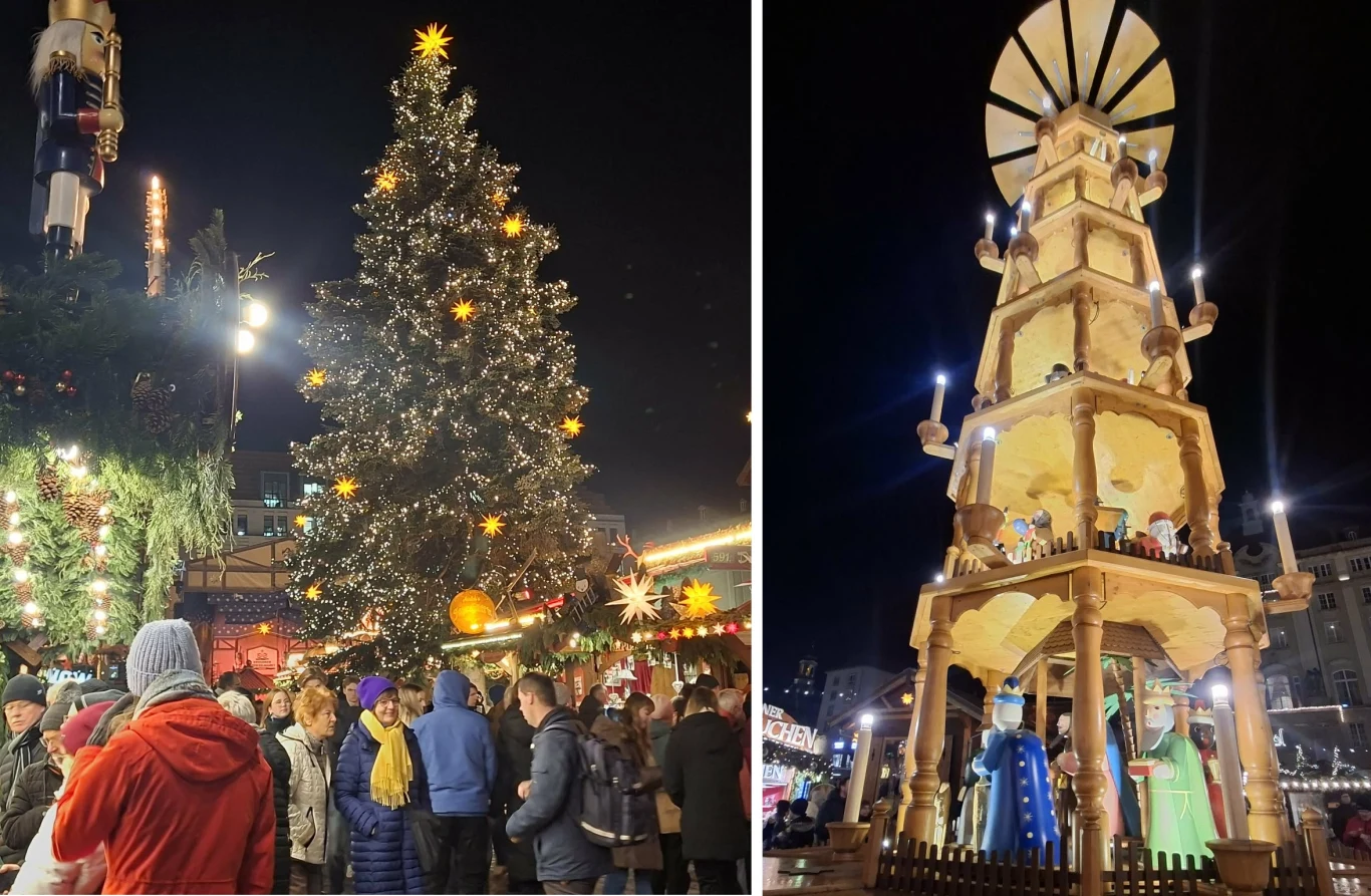 Uliczny jarmark bożonarodzeniowy z dużą choinką ozdobioną światłami i gwiazdami oraz wysoką, drewnianą świąteczną piramidą z figurami. Wokół tłum ludzi cieszących się świąteczną atmosferą.