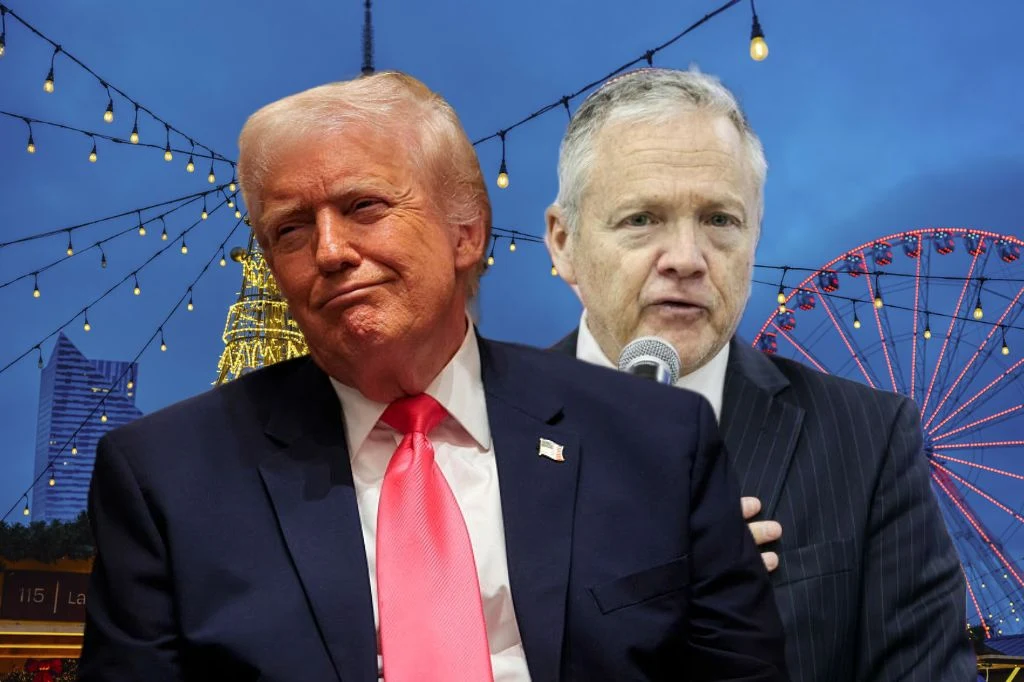 Ambasador USA przekazał Polsce życzenia. "W imieniu Donalda Trumpa" Dwóch mężczyzn w garniturach, jeden z nich przemawia do mikrofonu, w tle widoczne kolorowe światła, iluminacje oraz diabelski młyn.