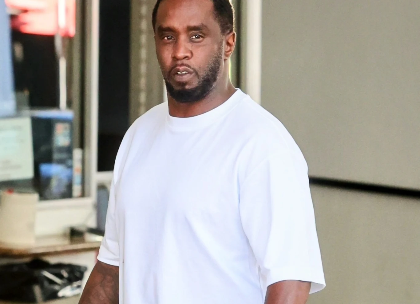 Diddy wniósł apelację o wcześniejsze zwolnienie z więzienia Mężczyzna o ciemnej karnacji w białej koszulce z krótkim rękawem stoi w jasnym pomieszczeniu, skierowany twarzą do obiektywu, tło niewyraźne, we wnętrzu widoczne są elementy wystroju.