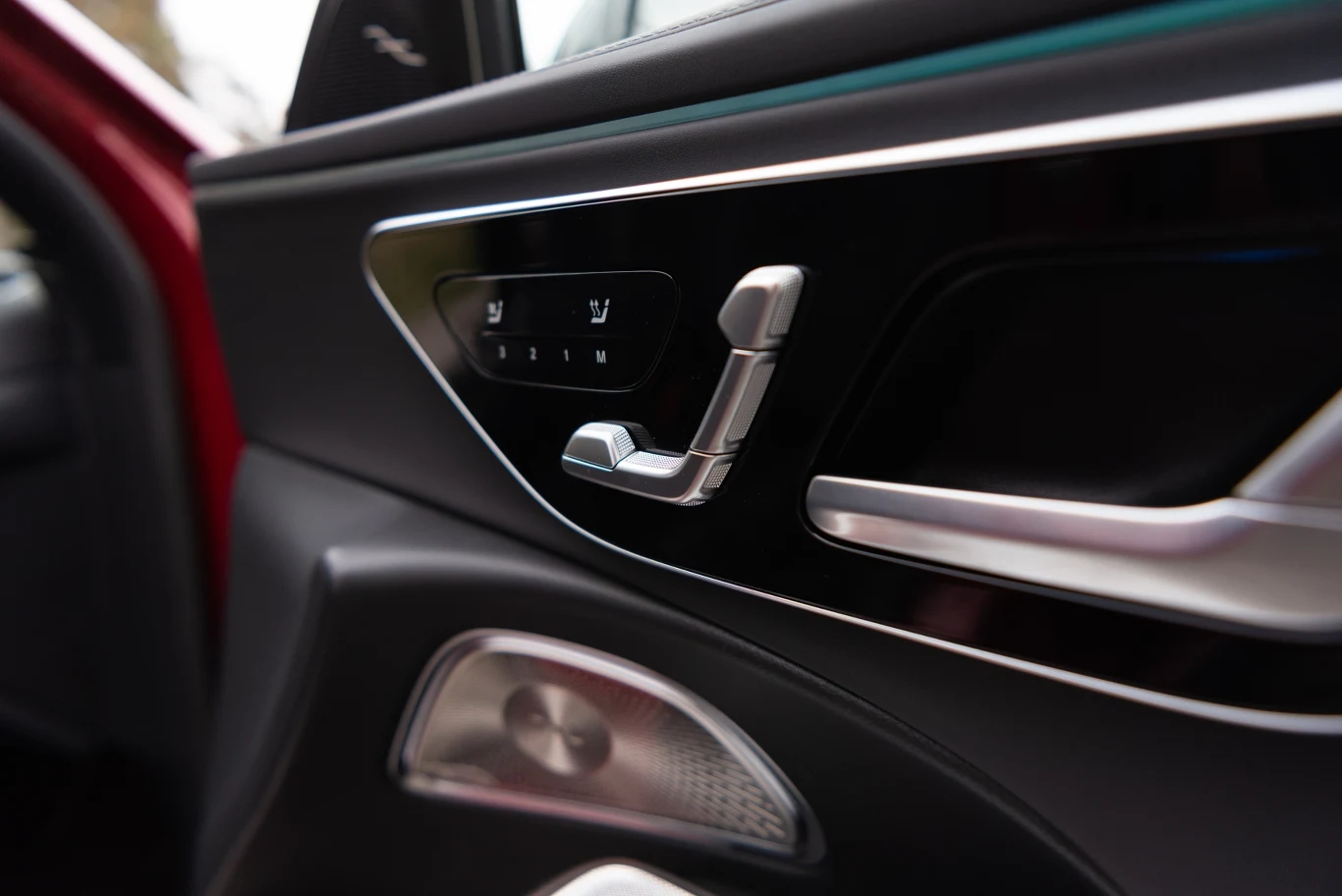 Kokpit wewnętrznych drzwi samochodu z widocznym panelem regulacji fotela oraz przyciskami do zapisywania ulubionej pozycji siedzenia. Luksusowe wykończenia w kolorze czarnym z elementami metalicznymi.