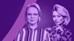 Dwie kobiety pozujące na fioletowym tle, jedna z nich nosi okulary i prążkowaną koszulę, druga ma krótkie, ułożone blond włosy i elegancką bluzkę, obie skierowane w stronę aparatu.