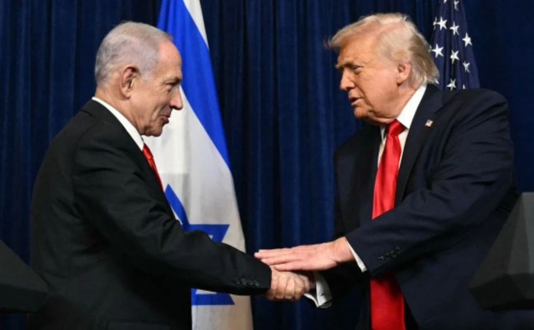 USA. Binjamin Netanjahu ogłosił, że Donald Trump otrzyma Nagrodę Izraela Dwaj mężczyźni w garniturach podają sobie ręce na tle flag narodowych Izraela i Stanów Zjednoczonych, obaj ubrani elegancko, patrząc na siebie podczas formalnej ceremonii.