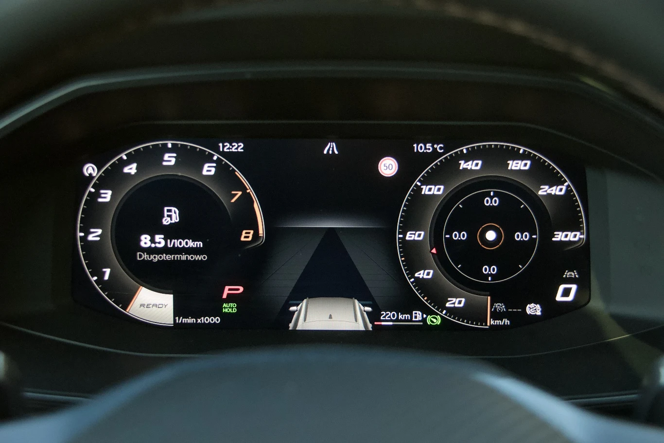 Cyfrowy panel wskaźników samochodu, z czytelnymi licznikami prędkości, obrotów silnika, wskaźnikiem paliwa i ekranem informacyjnym wyświetlającym zużycie paliwa oraz aktualny tryb jazdy.