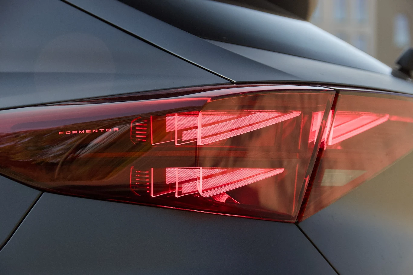 Tylna lampa LED samochodu marki Cupra Formentor, nowoczesny design, ostre linie świateł i metaliczna karoseria.