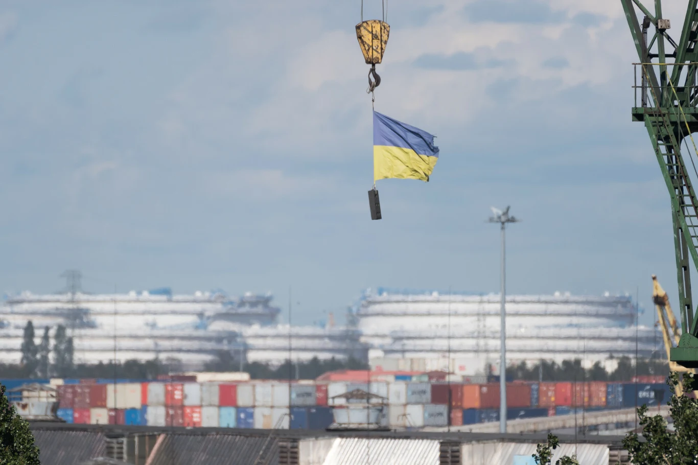 Co dziesiąta rejestrowana w Polsce działalność gospodarcza jest prowadzona przez Ukraińców - wynika z ustaleń "Rzeczpospolitej" Dźwig unoszący flagę Ukrainy nad portem kontenerowym, w tle duże budynki i wypełnione kontenerami nabrzeże.