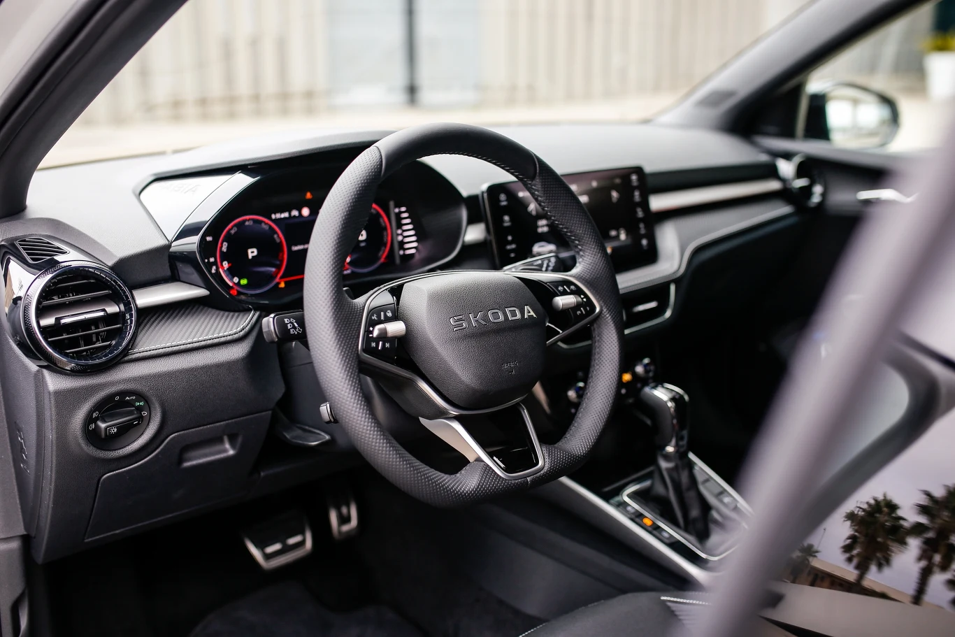 Nowoczesna deska rozdzielcza samochodu marki Skoda z cyfrowymi zegarami, wielofunkcyjną kierownicą oraz dużym ekranem dotykowym w konsoli centralnej.