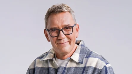 Dariusz Wardziak, czyli Darek Stolarz w okularach, kraciastej koszuli, uśmiechnięty