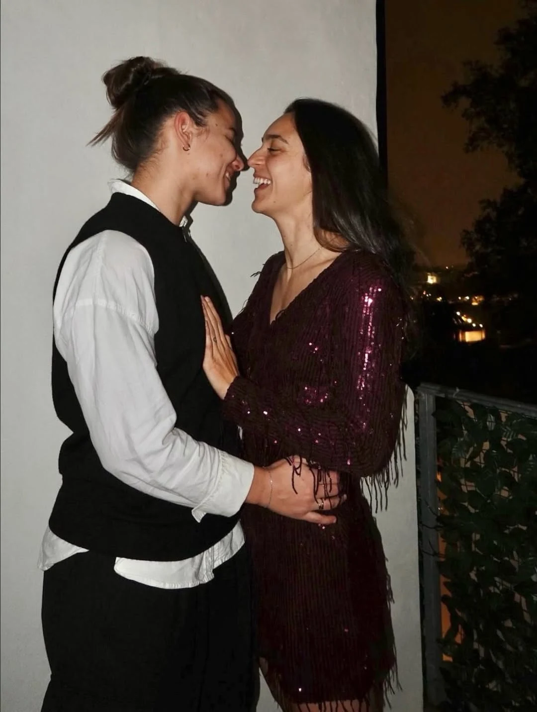 Natalia Padilla-Bidas jest w związku z koleżanką z klubu Dwie osoby stoją blisko siebie na balkonie, uśmiechają się i patrzą sobie w oczy, okazując czułość oraz radość. W tle widoczny fragment nocnego krajobrazu miasta i cienka balustrada z liściastym wzorem.