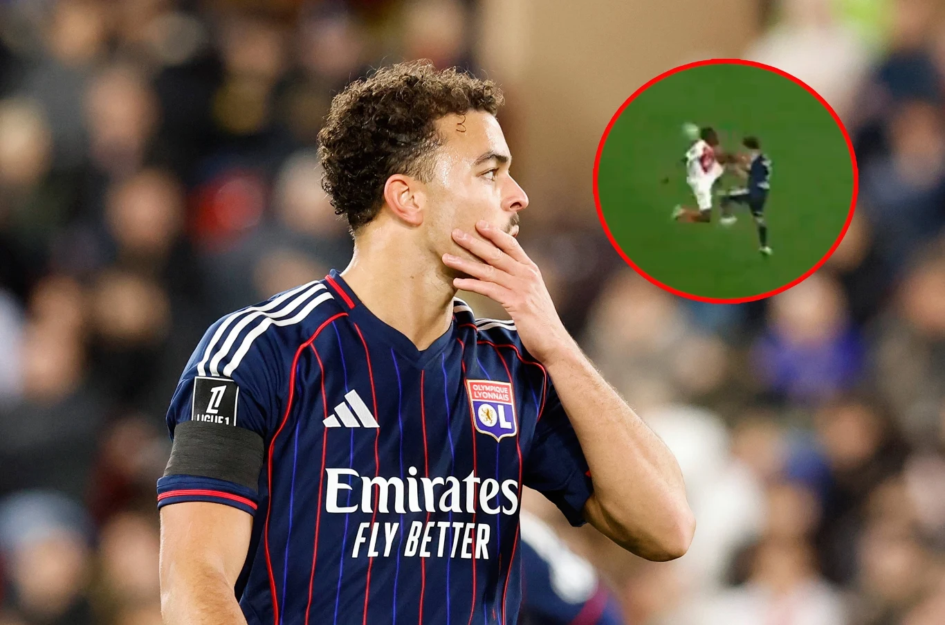 Faul w meczu Monaco - Lyon Piłkarz Lyonu w ciemnym stroju z ręką przy twarzy na pierwszym planie, w prawym górnym rogu kółko z powiększonym ujęciem akcji meczowej z udziałem dwóch zawodników.