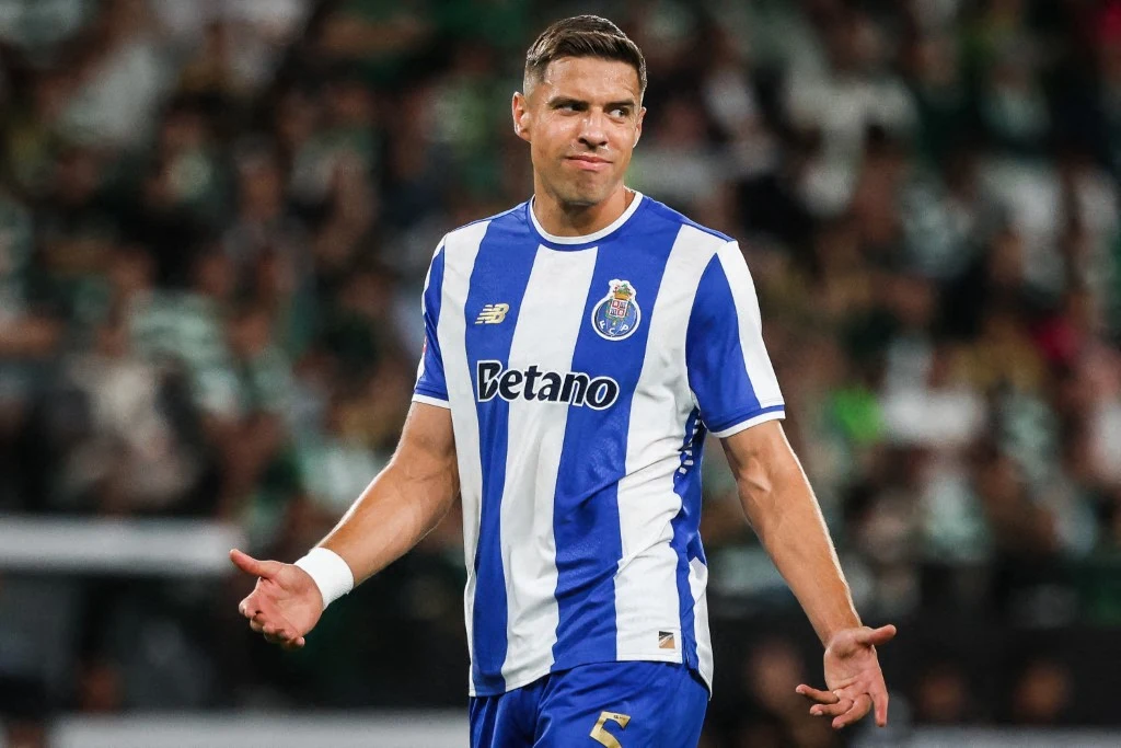 Jan Bednarek i Jakub Kiwior docenieni po meczu Santa Clara - FC Porto Piłkarz w stroju klubowym FC Porto z numerem 3 wykonuje gesty rozkładając ręce, wyraz twarzy sugeruje zdziwienie lub niezadowolenie, w tle rozmyta publiczność i zielone barwy stadionu.