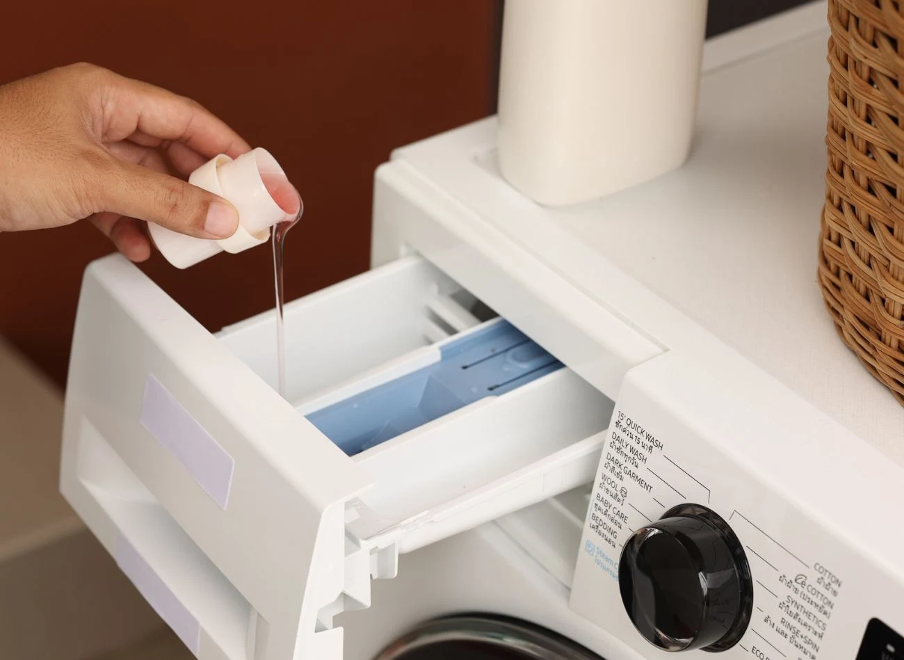 Komory w szufladzie pralki pokazują gdzie wlać detergent, zgodnie z przeznaczeniem prania.
