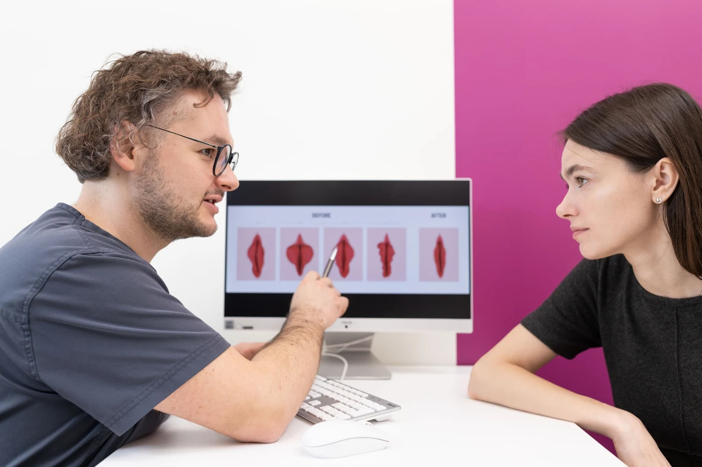 Lekarz omawiający z pacjentką ilustracje różnych kształtów narządów intymnych na ekranie komputera w gabinecie medycznym.