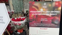 Stojak z bukietami czerwonych gwiazd betlejemskich oraz tablica informacyjna o przedświątecznej zbiórce elektrycznych śmieci organizowanej przez Polsat Media, otoczone świątecznymi dekoracjami świetlnymi.