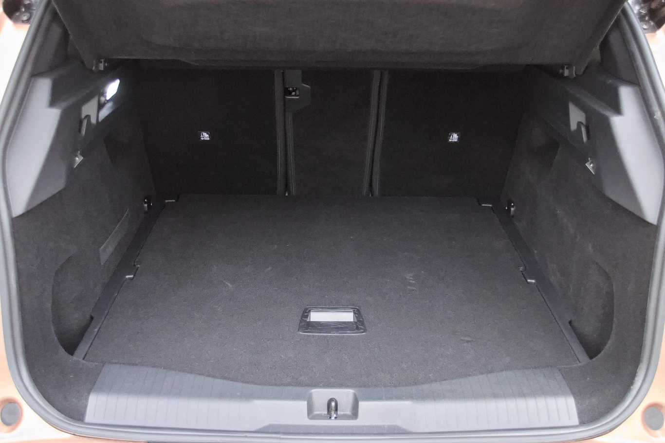 Przestronny bagażnik samochodowy z czystą, czarną wykładziną i podniesioną klapą, bez widocznych przedmiotów czy dodatkowych akcesoriów.