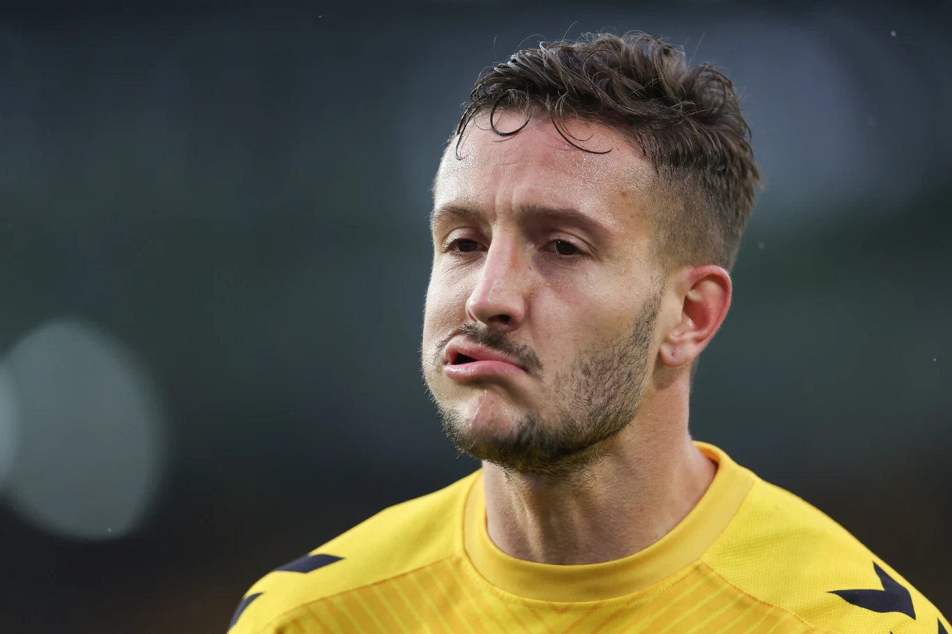 Borja Galan - GKS Katowice Piłkarz w żółtej koszulce podczas meczu, z wyrazem frustracji na twarzy, sfotografowany z bliskiej odległości.