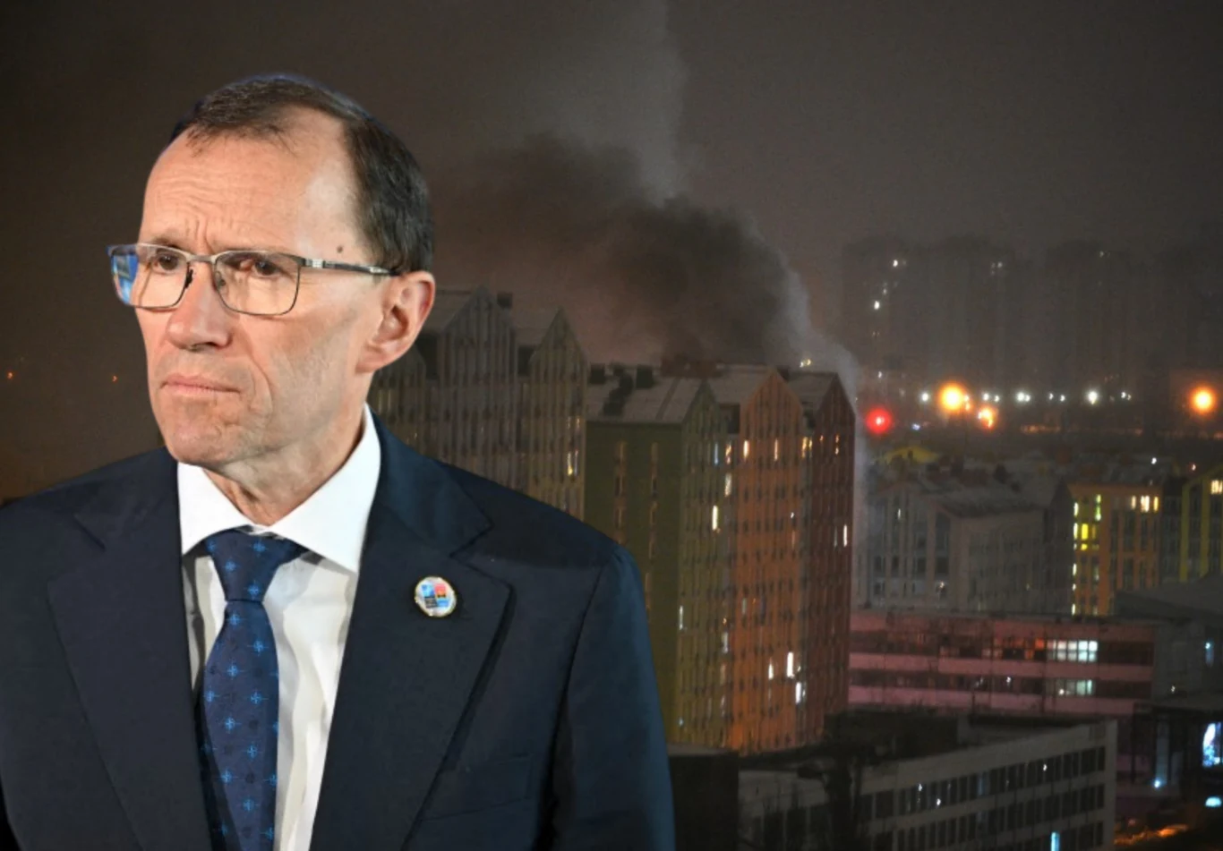 Norwegia przekaże Ukrainie w trybie pilnym pomoc o wartości 4 mld koron. Na zdj. szef norweskiej dyplomacji Espen Barth Eide Mężczyzna w okularach, ubrany w garnitur i krawat, na tle nocnego miasta, w którym nad budynkami unosi się dym oraz widoczne są światła uliczne.
