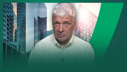 Mężczyzna o siwych włosach w jasnej koszuli na tle nowoczesnych szklanych biurowców, z wyraźnym zielonym graficznym akcentem po prawej stronie.