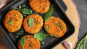 Kotlety z soczewicy na patelni z listkami szpinaku dla ozdoby