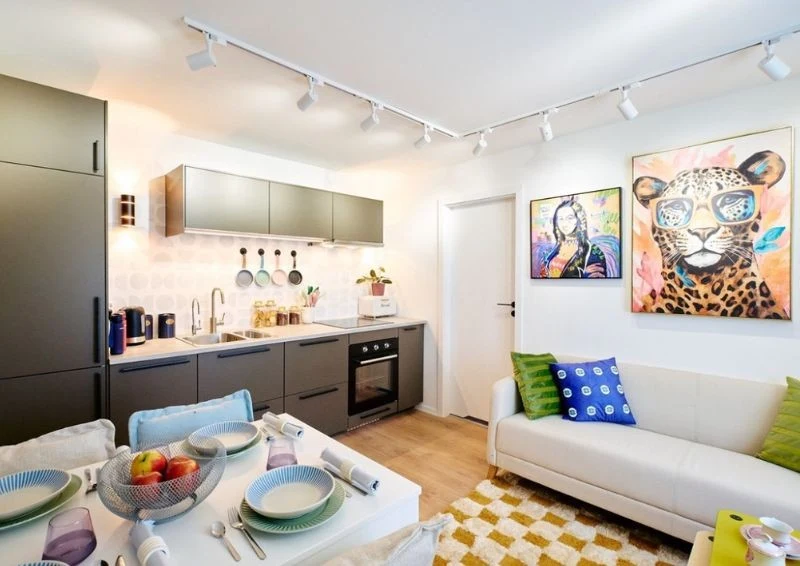 Ciemne meble kuchenne kontrastują z pozostałymi elementami salonu