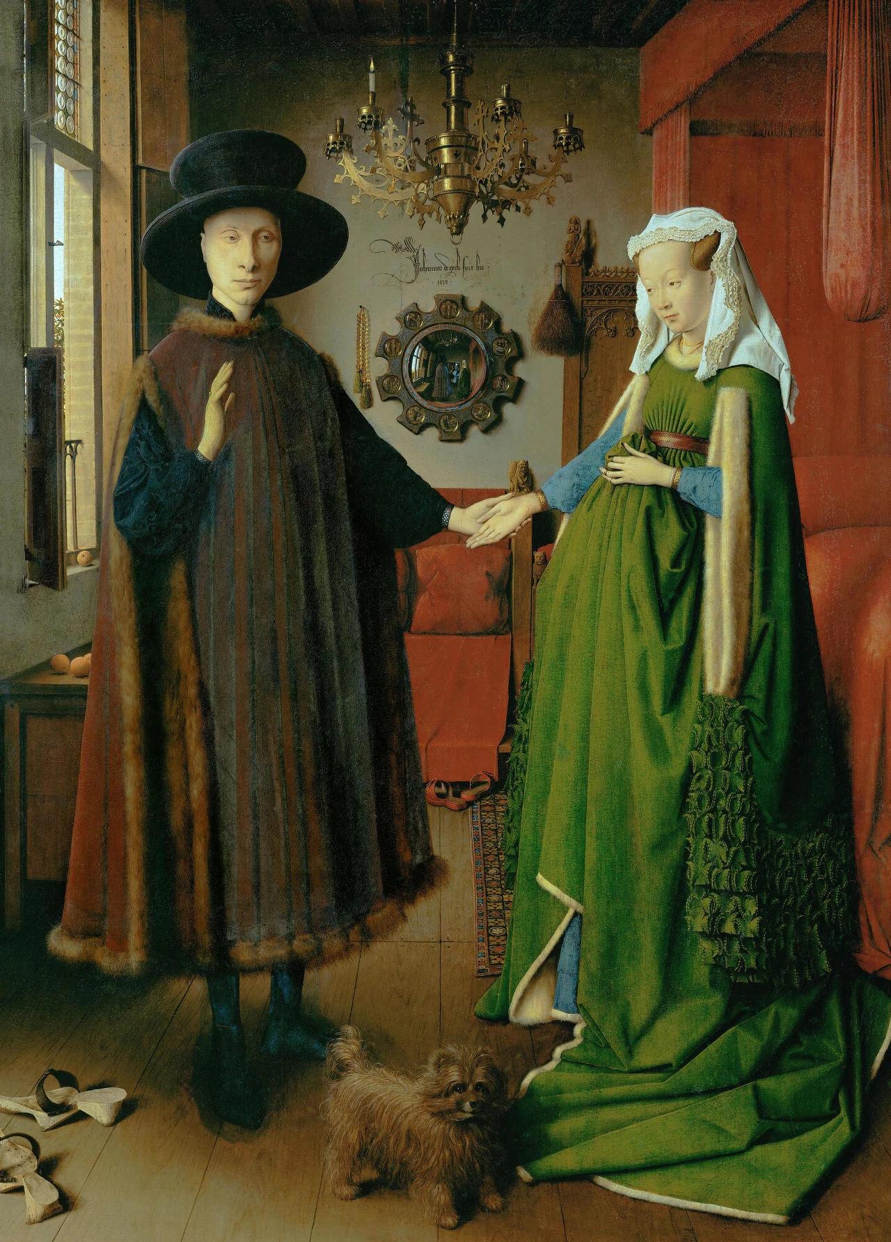 Para ubrana w bogate, dawne stroje stoi we wnętrzu eleganckiego pokoju. Mężczyzna trzyma delikatnie dłoń kobiety, która ma na sobie obszerną zieloną suknię. W tle widoczne jest ozdobne lustro, żyrandol i łóżko z baldachimem. Na podłodze biega pies.