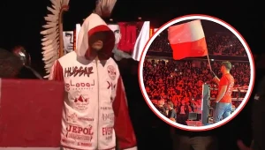 Damian Knyba na głównym planie, w momencie wejścia do ringu. W kółku Eryk Rachwał, machający z wysokości ringu biało-czerwoną flagą