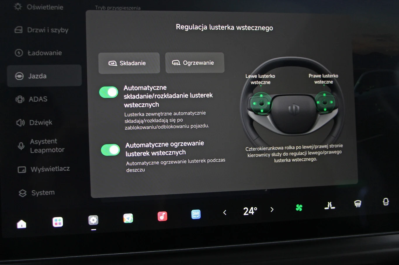 Ekran dotykowy samochodu wyświetlający opcje regulacji lusterek wstecznych, z widocznymi trybami składania, ogrzewania oraz automatycznym sterowaniem i opisami funkcji.