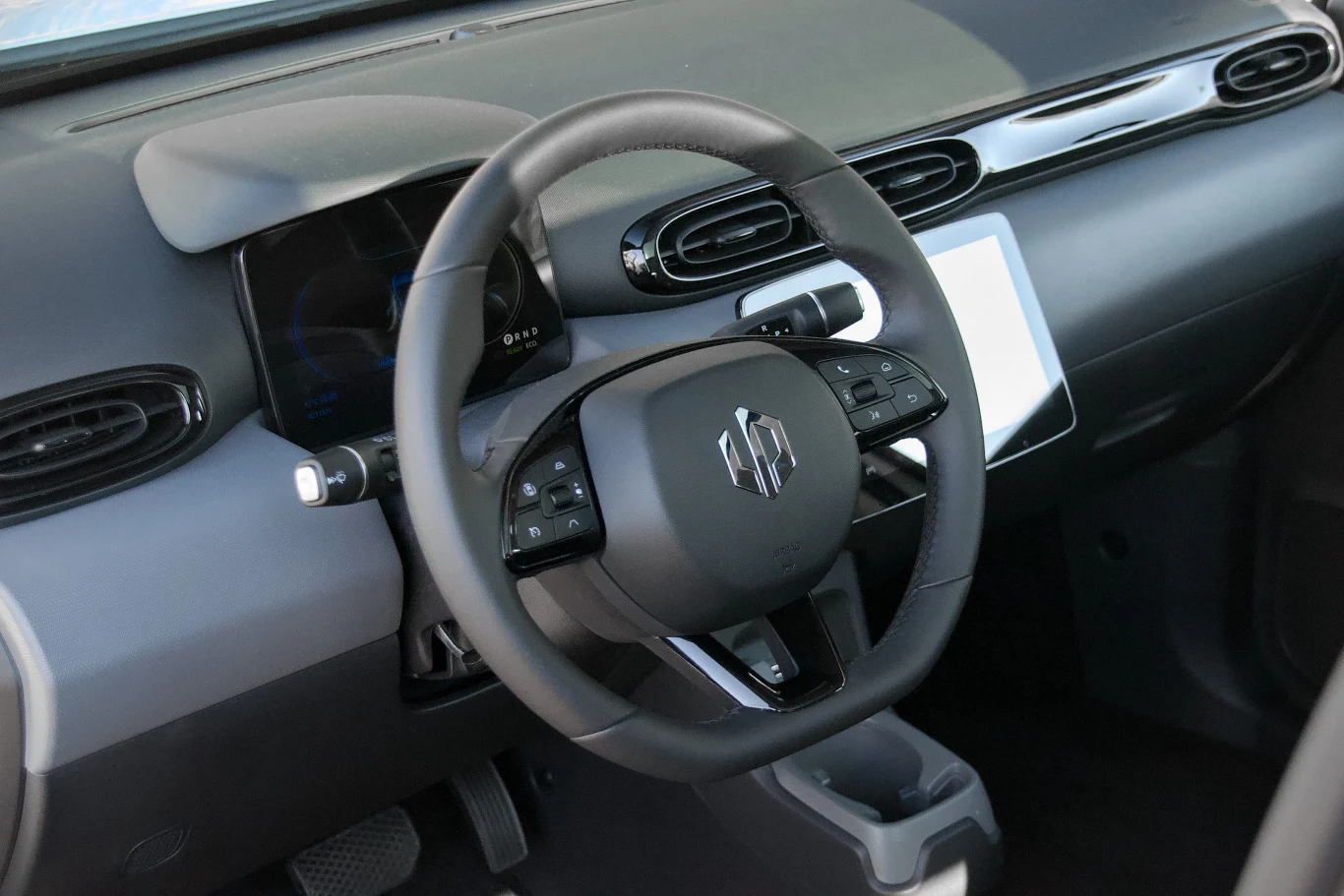 Kierownica z wielofunkcyjnymi przyciskami, cyfrowy kokpit, minimalistyczna deska rozdzielcza z nowoczesnym panelem sterowania oraz wnętrze zaprojektowane w stylu futurystycznym.