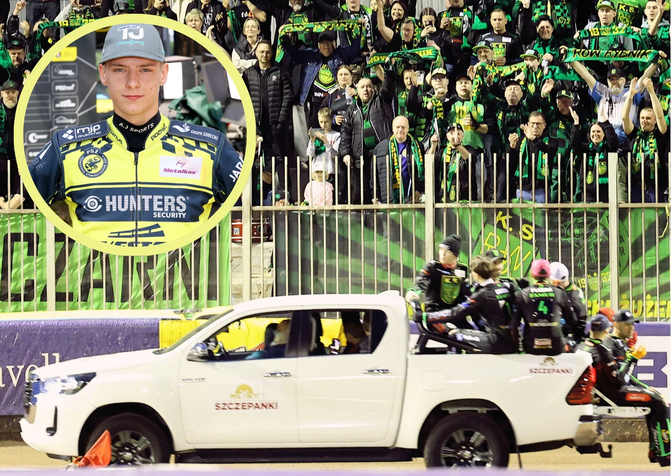 ROW Rybnik wszystko dokładnie policzył i wyszło na to, że transfer Tobiasza Musielaka nie ma sensu. Duża grupa kibiców ubranych w zielono-czarne barwy z szalikami uniesionymi w górze kibicuje za metalowym ogrodzeniem. Na pierwszym planie biały samochód terenowy, na którego skrzyni siedzi kilku zawodników drużyny sportowej w kaskach oraz zielono-czarn...