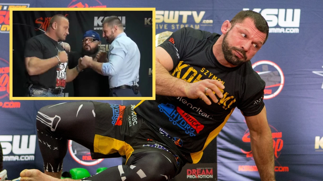 Zawodnik sportów walki w stroju sportowym siedzi na macie z logotypami sponsorów, na pierwszym planie wyraźne oznaczenia KSW. W prawym górnym rogu widoczna jest wstawka pokazująca trzech mężczyzn podczas konferencji lub face-offu przed walką.