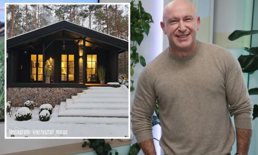 Uśmiechnięty mężczyzna ubrany w beżowy sweter stoi na tle jasnego wnętrza ozdobionego zielenią, obok widoczna jest fotografia przytulnego, ciemnego domu wśród drzew, wokół którego leży śnieg.