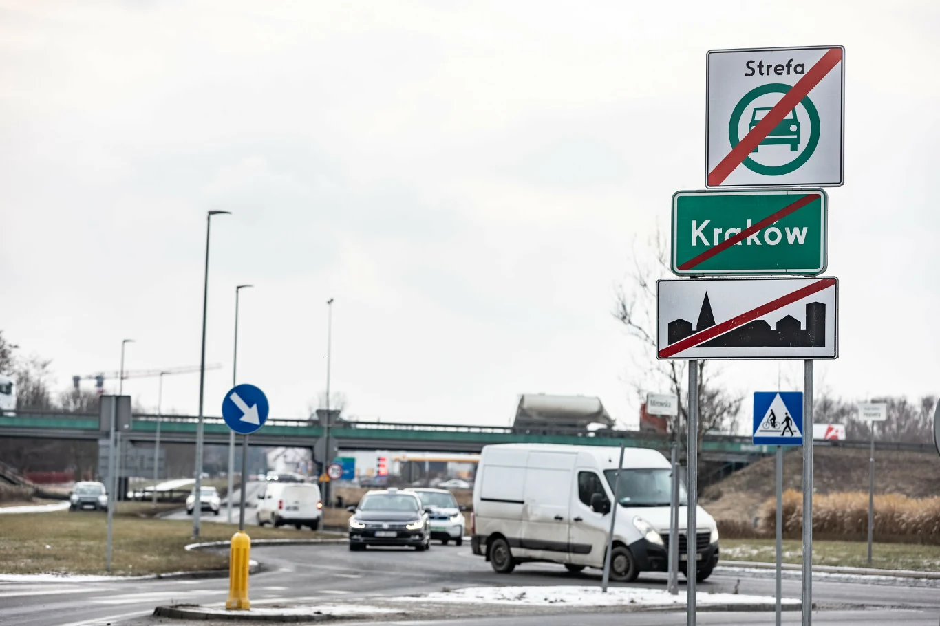 W wielu miejscach granice SCT pokrywają się z granicami Krakowa Samochody jadące po drodze wyjazdowej z miasta, znak drogowy informujący o końcu strefy ograniczonego ruchu dla pojazdów o określonej emisji oraz wyjeździe z Krakowa, w tle estakada i miejski krajobraz.