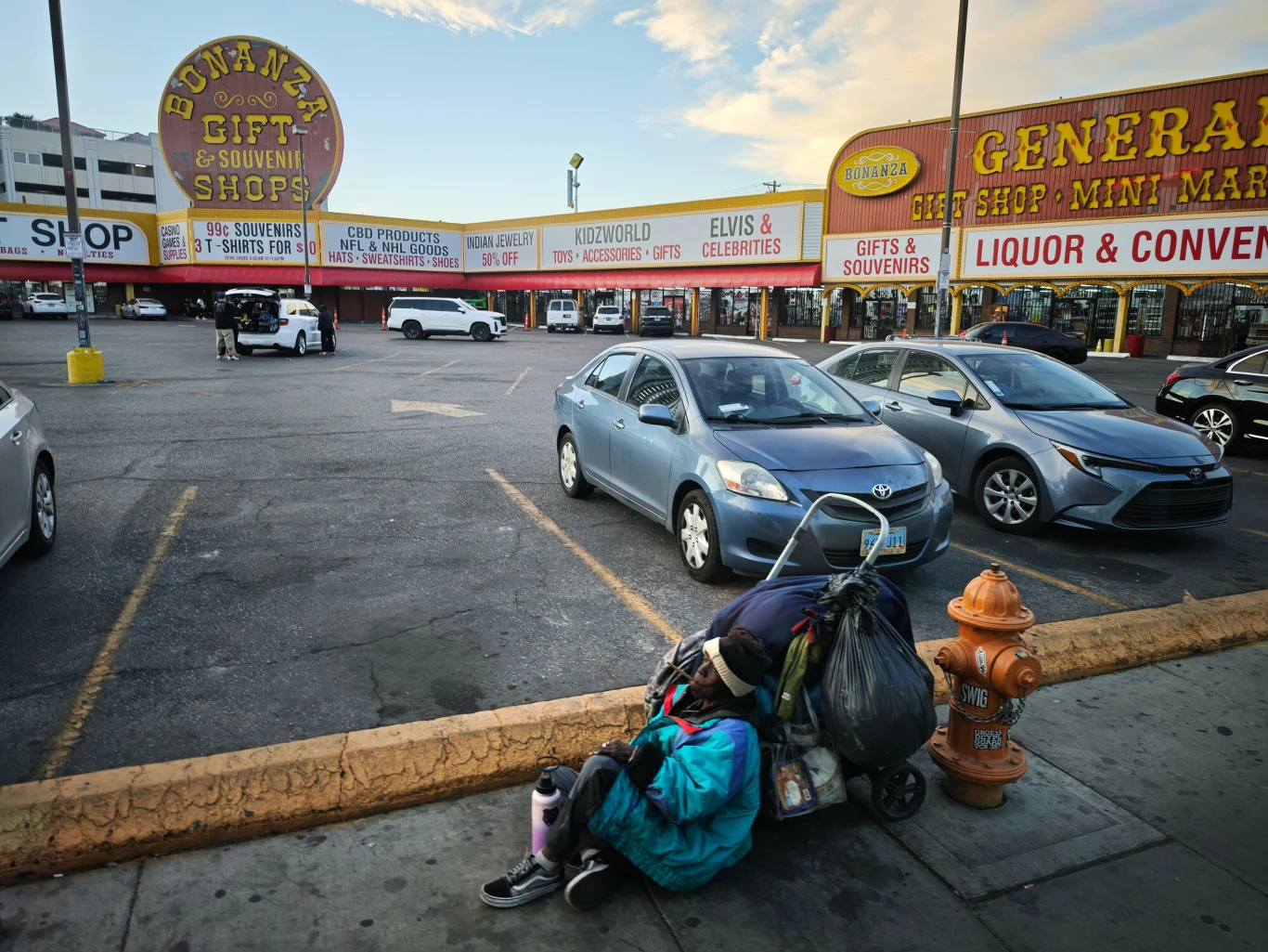 Poziom nierówności majątkowej w USA osiągnął najwyższych poziom od końca lat 80. Pod sklepami z pamiątkami i alkoholem na parkingu stoi zaparkowany samochód, a na chodniku w pobliżu hydrantu znajduje się osoba siedząca obok wózka z licznymi torbami i rzeczami osobistymi.