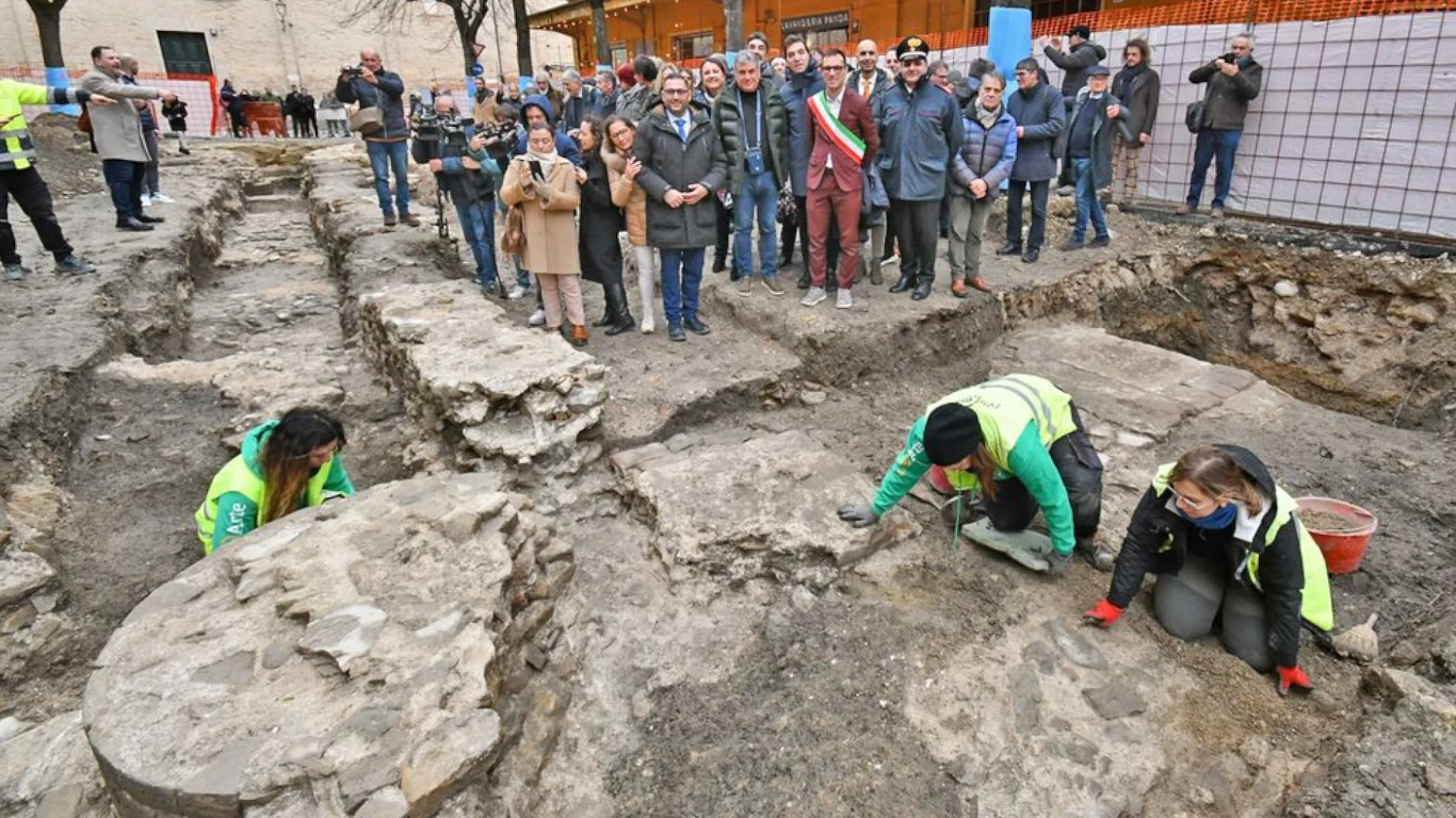 Archeolodzy są pewni. Udało się odkryć jedną z zaginionych bazylik starożytnego Rzymu Prace archeologiczne prowadzone przez trzy osoby w kamiennych wykopaliskach, w tle grupa ludzi obserwujących wydarzenie, w tym urzędnicy i media.