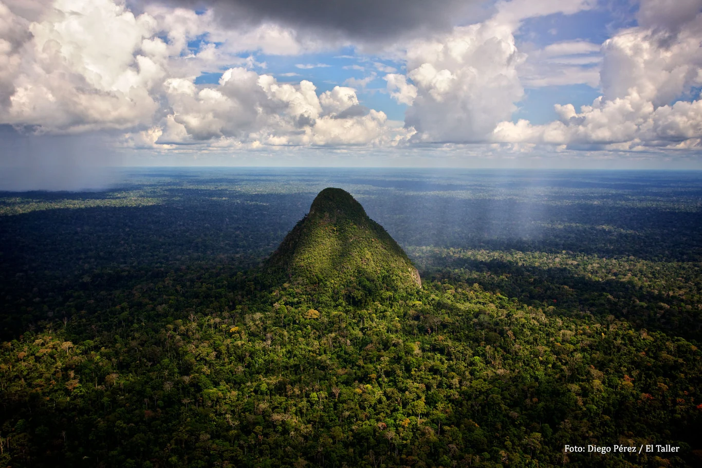 Głęboko w Amazonii, na trudno dostępnym obszarze peruwiańskiej dżungli, znajduje się niezwykła formacja, która przypomina piramidę. Samotne, skaliste wzniesienie otoczone gęstą, zieloną dżunglą tropikalną, nad którą unoszą się gęste chmury i promienie światła przebijające się przez pochmurne niebo.