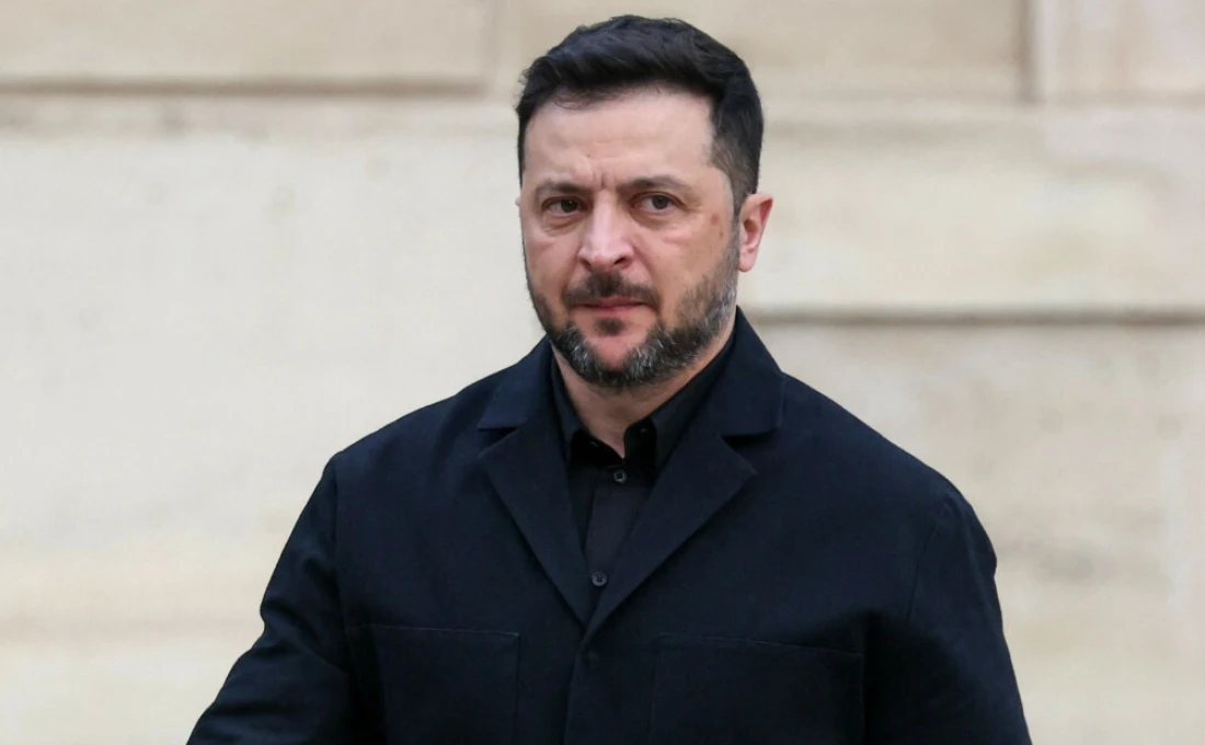 Ukraina- Rosja. Wołodymyr Zełenski zdradził szczegóły o "pakcie Dmitrijewa" (zdj. ilustracyje) Mężczyzna w ciemnej marynarce stoi w jasnym otoczeniu. Ma krótkie, ciemne włosy i brodę. Jego wyraz twarzy jest poważny. W tle rozmazane ściany o jasnym kolorze.