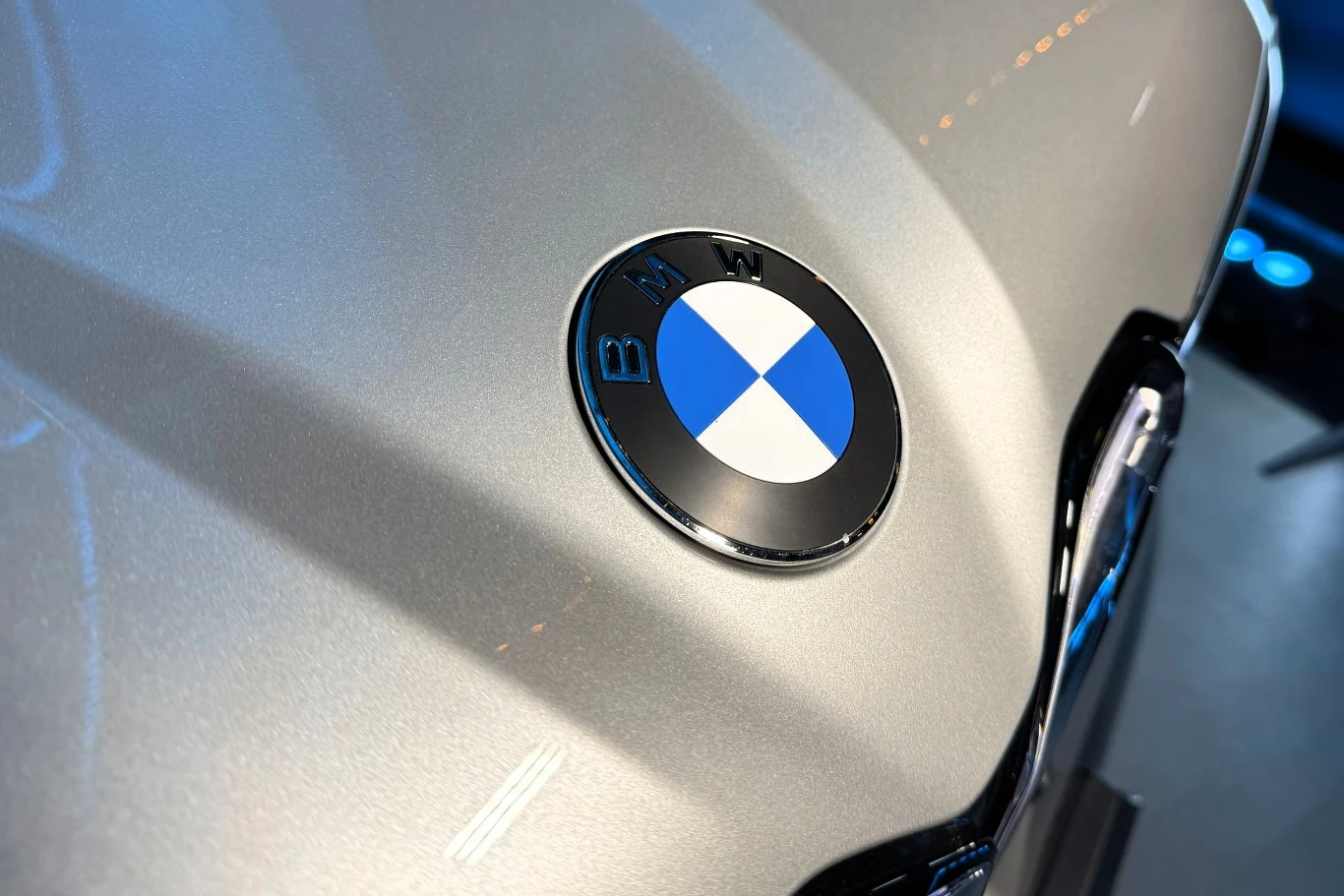 BMW uplasowało się na pierwszym miejscu producentów samochodów premium w Polsce w 2025 roku. Metaliczna powierzchnia maski samochodu z widocznym, wyraźnym logo marki BMW w centralnym punkcie kadru.