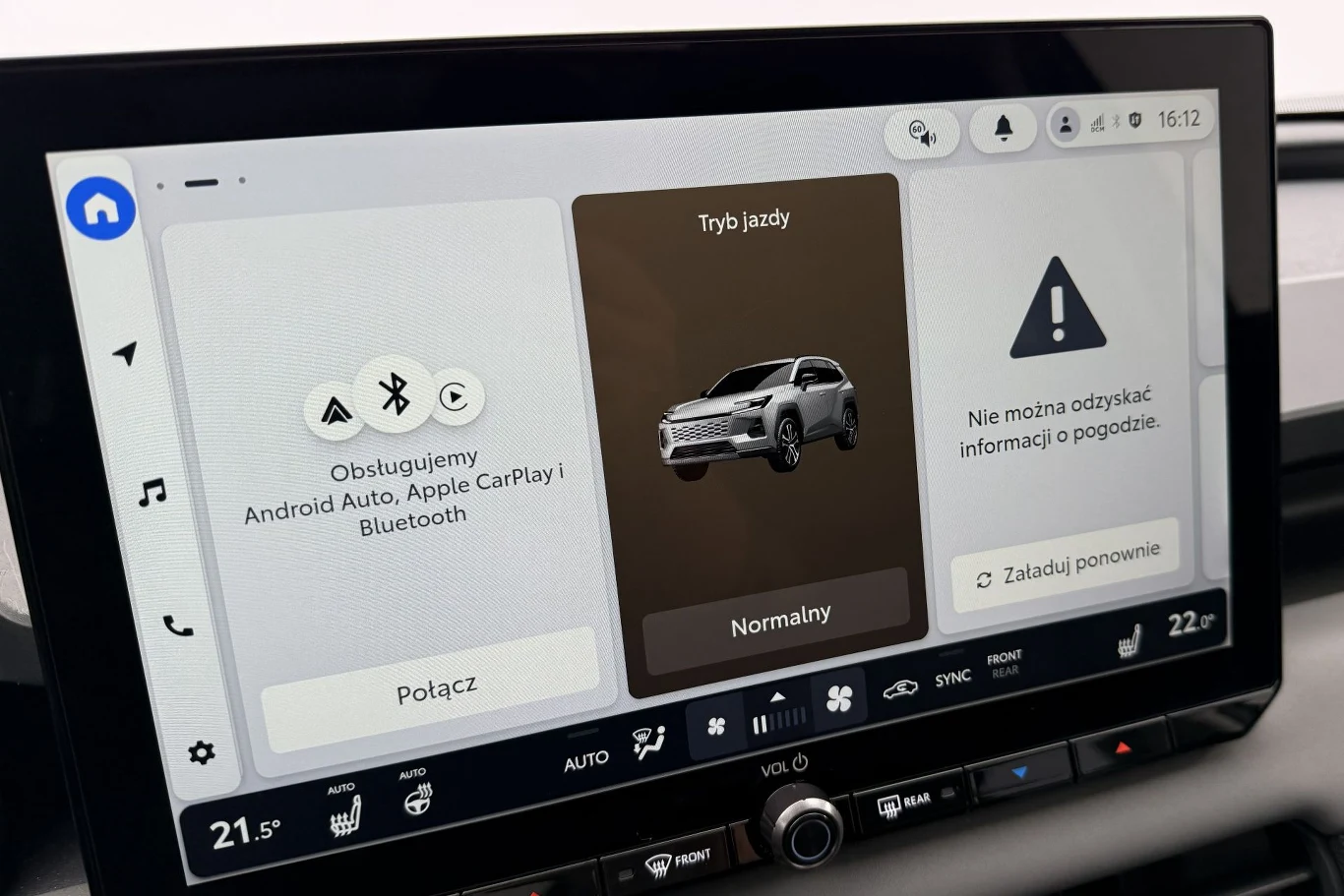 Znaczącą większość funkcji obsługujemy z poziomu 12,9-calowego ekranu multimediów. Dzięki nowemu systemowi operacyjnemu układ inforozrywki działa szybciej niż w poprzedniej generacji. Nowoczesny ekran systemu multimedialnego samochodu wyświetlający opcje połączenia Android Auto i Apple CarPlay, wybór trybu jazdy oraz ostrzeżenie o braku dostępu do informacji o pogodzie. Widoczne intuicyjne menu, przyciski dotykowe oraz panel sterowa...