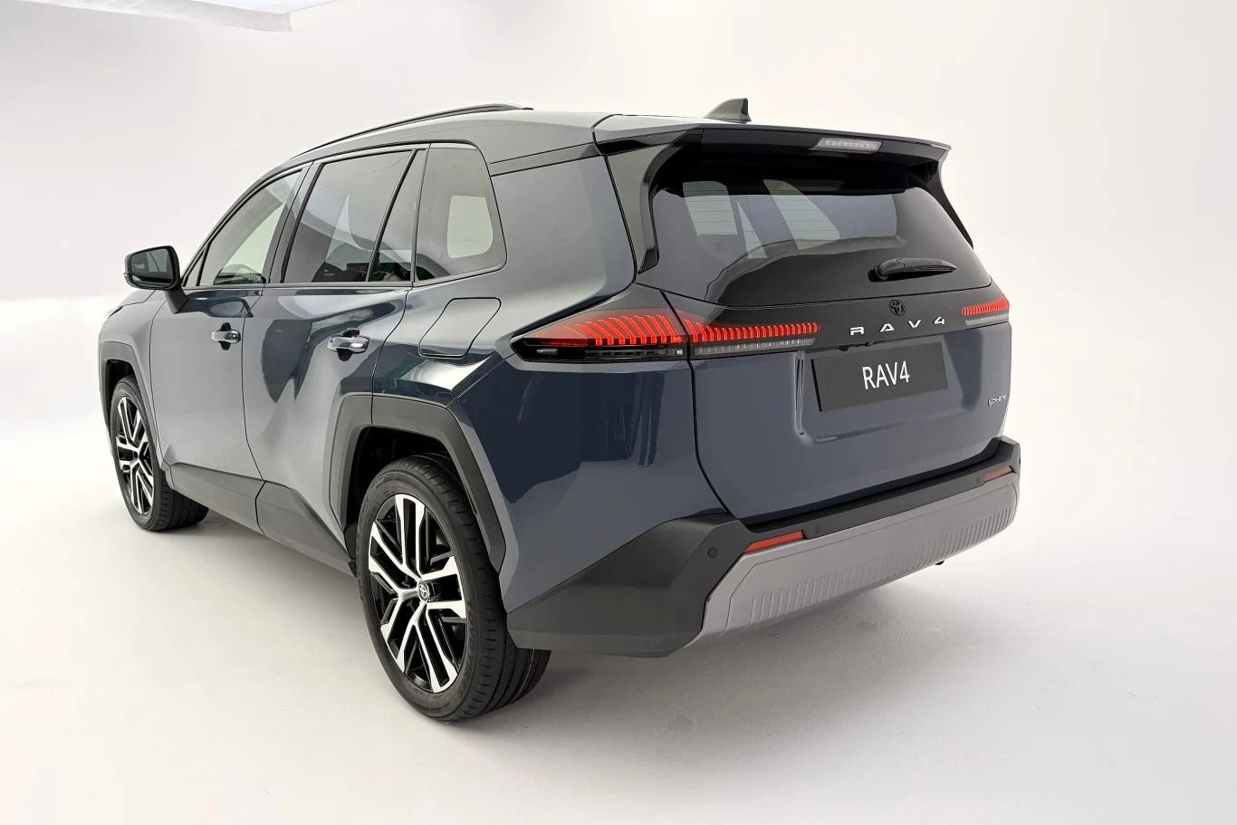 Nowa Toyota RAV4 w ramach przedsprzedaży dostępna jest od 181 600 zł (w ramach promocji). Od 7 stycznia Polacy złożyli zamówienia na ponad 1 tys. samochodów. Nowoczesny SUV w ciemnoszarym kolorze, sfotografowany z tyłu pod lekkim kątem, z widocznym napisem RAV4 na klapie bagażnika, charakterystycznymi tylnymi światłami LED i dużymi aluminiowymi felgami.