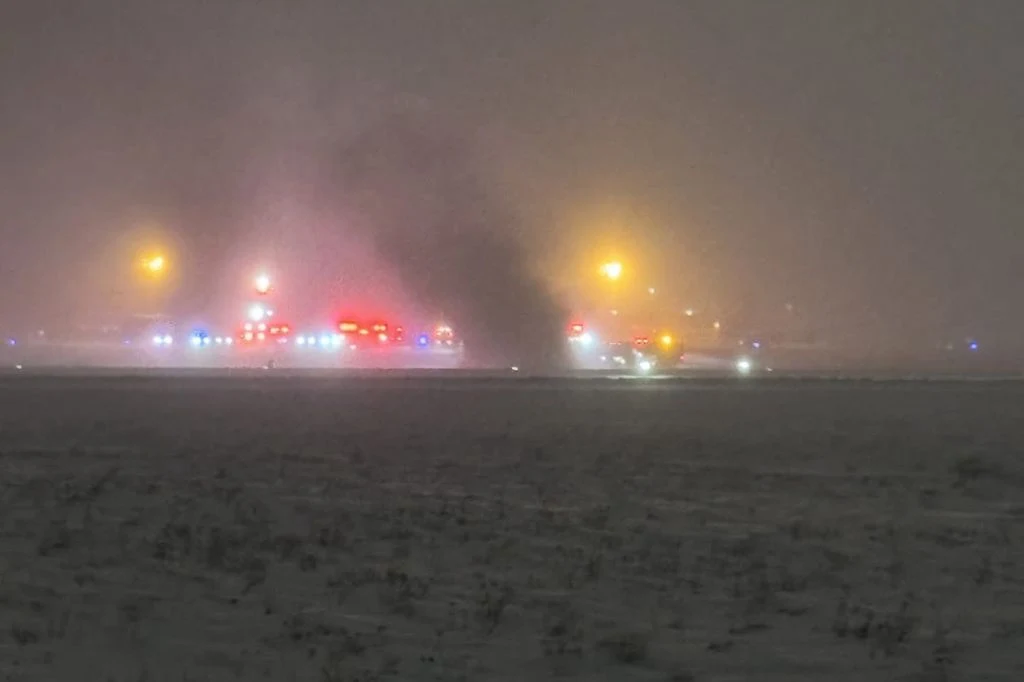 USA. Tragiczny wypadek na lotnisku w Maine. Siedem osób nie żyje Dym unoszący się z pasa startowego otoczonego przez pojazdy służb ratunkowych z włączonymi sygnałami świetlnymi podczas śnieżnej nocy na lotnisku