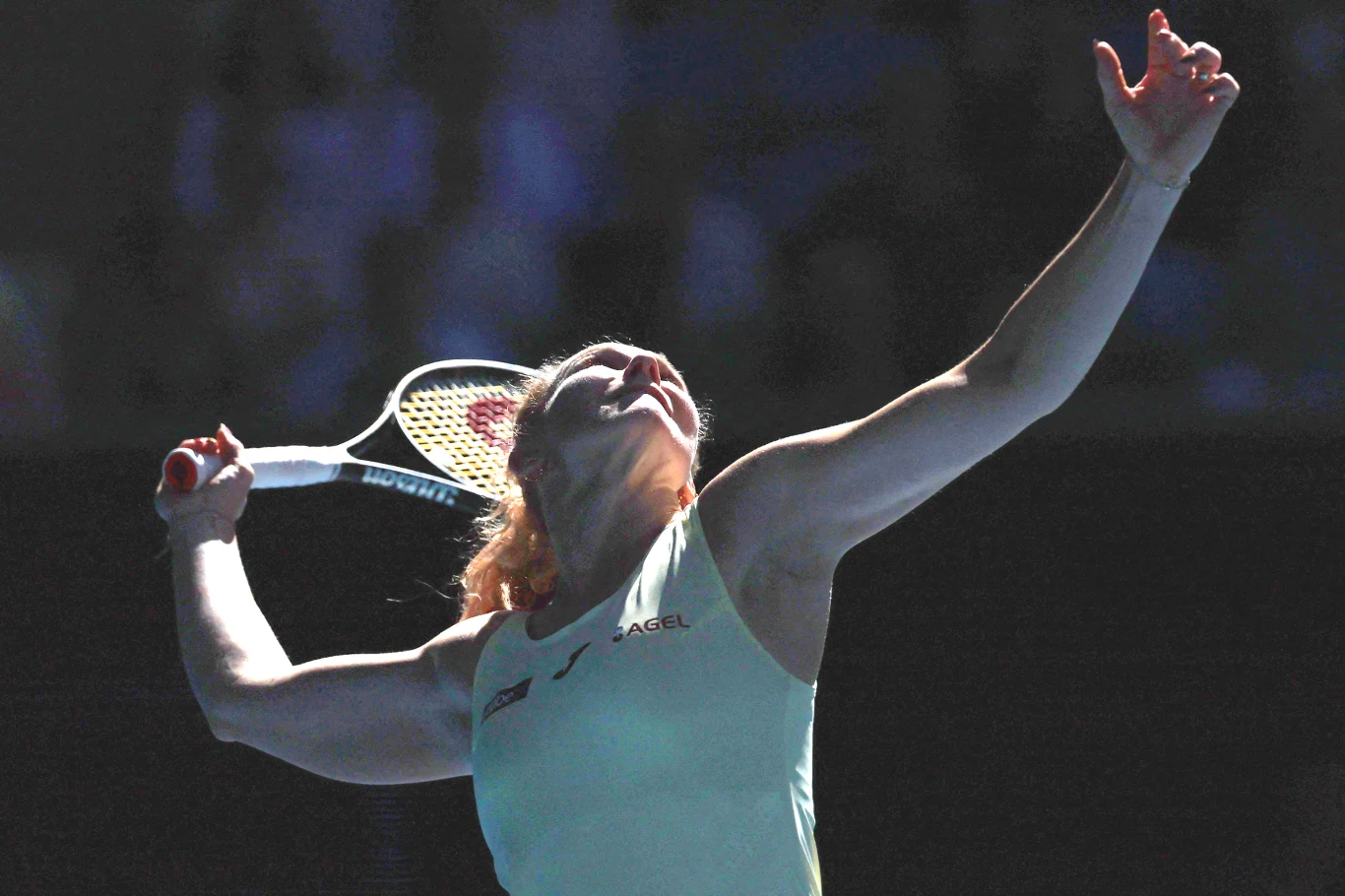 Katerina Siniakova, podobnie jak Iga Świątek, zdobyła tytuł na Wimbledonie 2025 Tenisistka w akcji podczas wykonywania serwisu w dynamicznym świetle na korcie, rakieta tenisowa uniesiona nad głową, skupienie widoczne na twarzy sportowczyni.