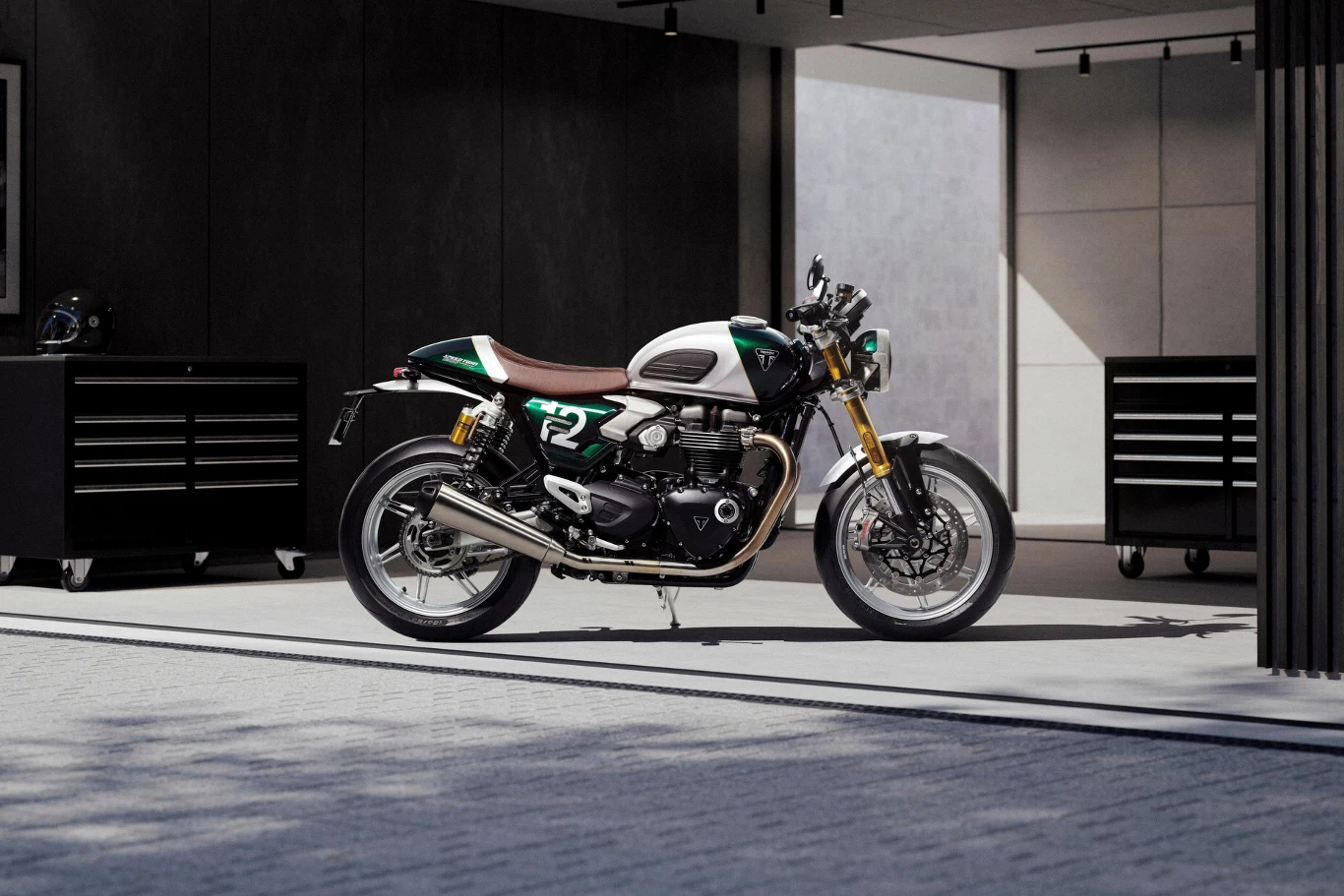 Sportowe osiągi ukryte w klasycznych liniach. Limitowana wersja bazuje na odmianie RS. Motocykl sportowy z numerem 72 na zbiorniku paliwa stoi w jasnym, przestronnym garażu. W tle znajdują się czarne skrzynki narzędziowe oraz ściany o minimalistycznym wykończeniu. Światło dzienne rozświetla pojazd, podkreślając jego detale.