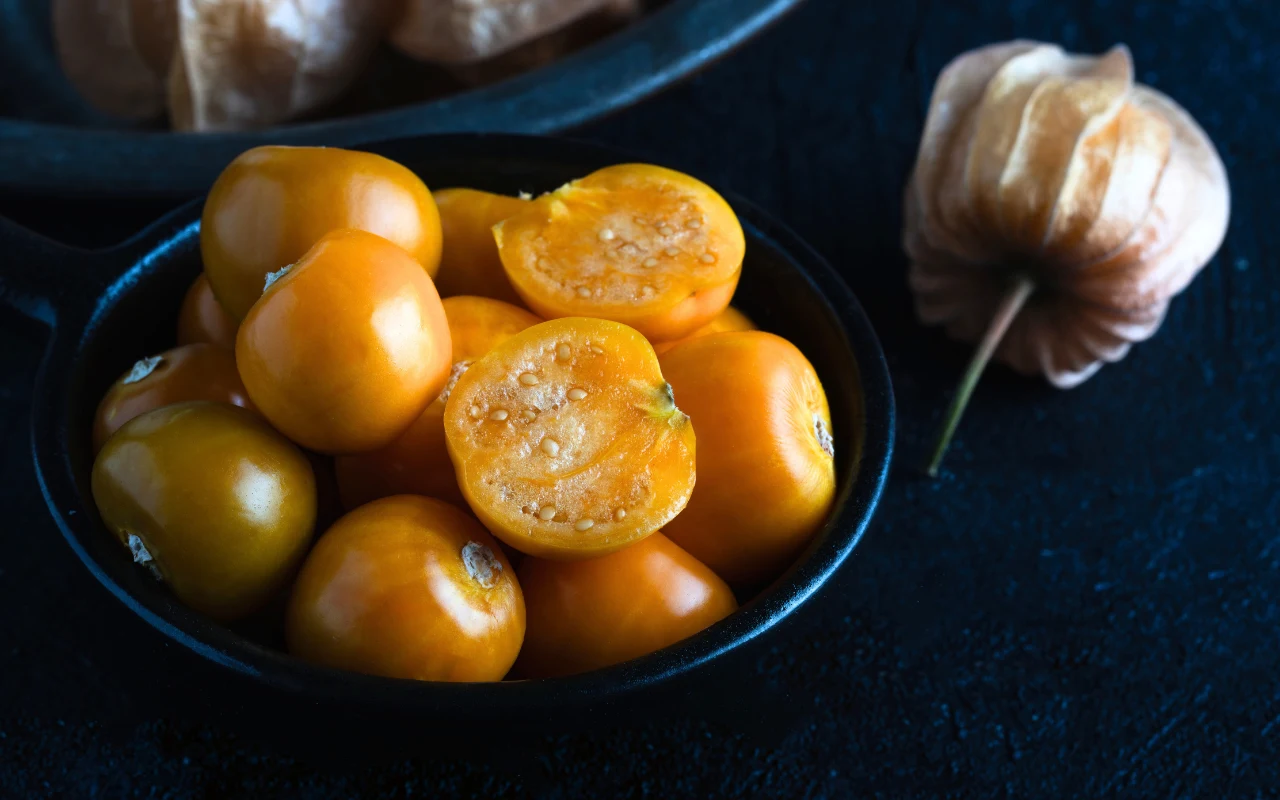 Bez płatków kwiatu, owoce miechunki przypominają małe, pomarańczowe pomidorki lub bardzo duże jagody