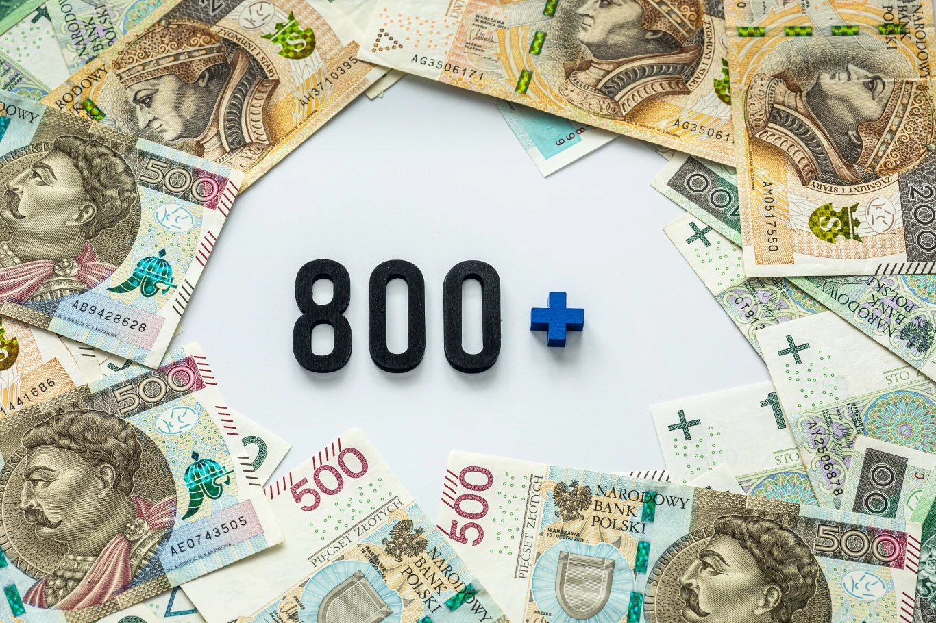 Czy ZUS może odebrać 800 plus? Napis 800+ na białym tle otoczony banknotami polskimi o nominałach 100, 200 i 500 złotych.