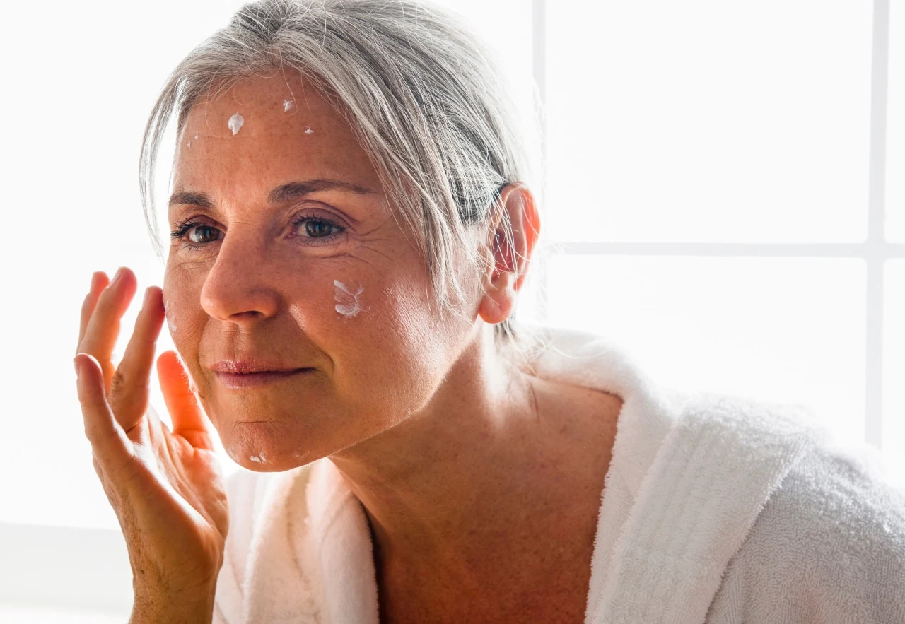 Dojrzała kobieta nakłada na twarz krem