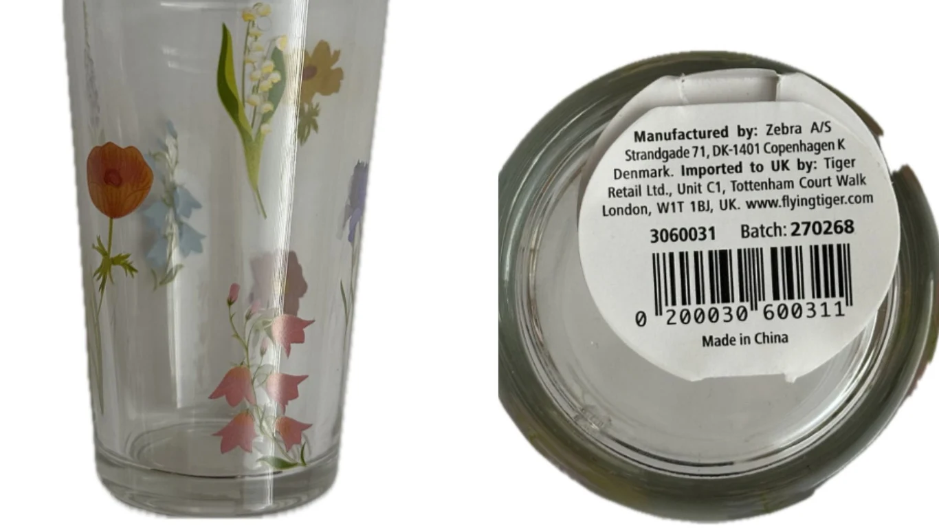 Szklanka w kwiaty 220 ml - Ostrzeżenie GIS Szklanka z motywem kolorowych kwiatów na przezroczystym tle, z widocznym spodem zawierającym etykietę producenta, kod kreskowy oraz informacje o imporcie i produkcji.