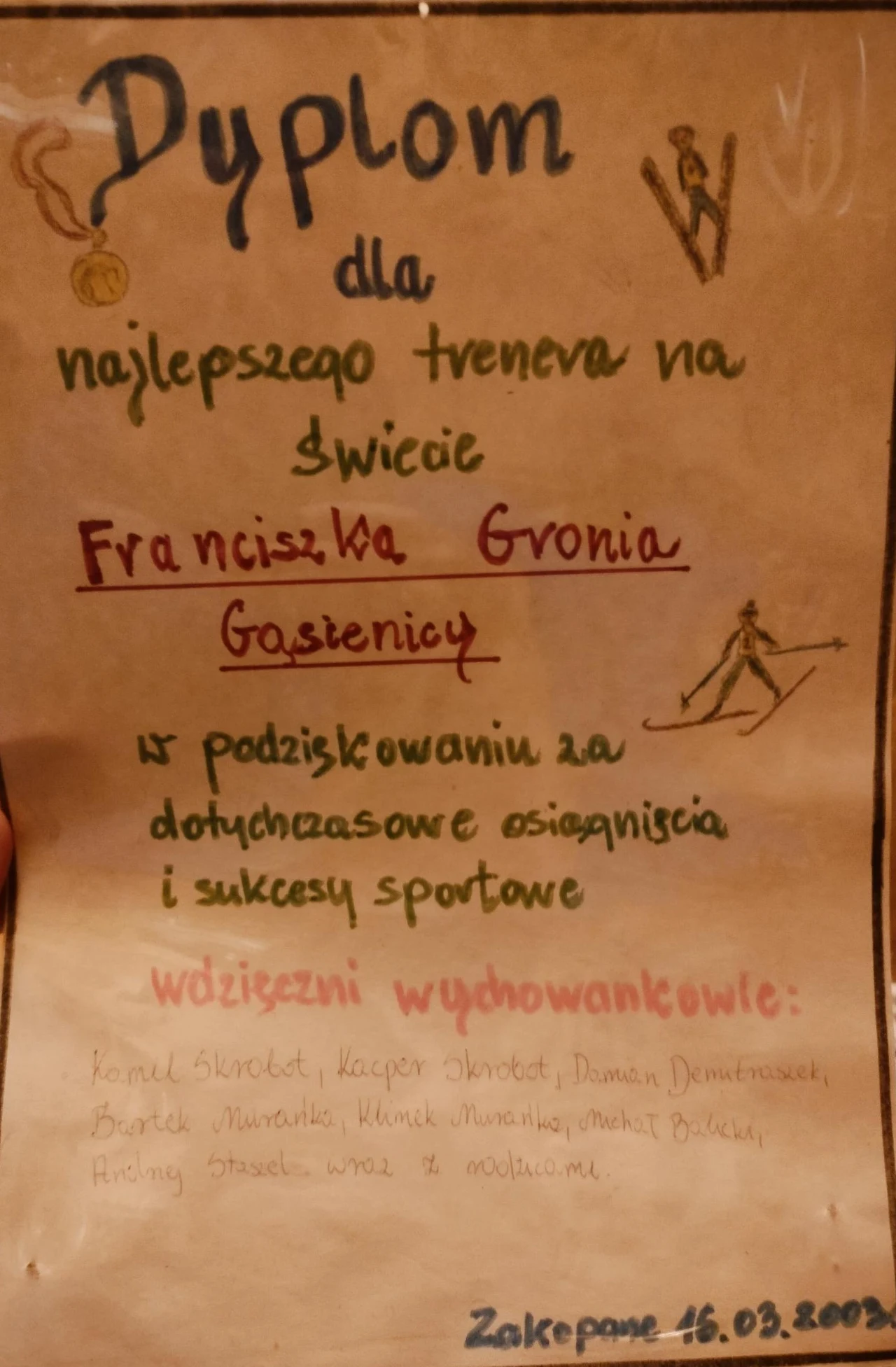 Dyplom odręcznie napisany dla najlepszego trenera na świecie, Franciszka Gronia-Gąsienicy, z podziękowaniami za osiągnięcia i sukcesy sportowe, podpisany przez wychowanków; widoczne odręczne rysunki sportowe oraz data i miejsce wręczenia, Zakopane, 16....