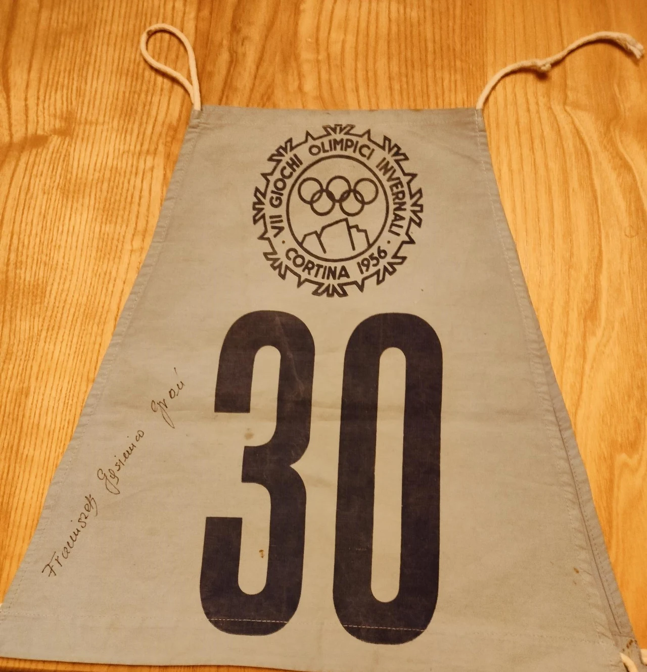 Numer startowy z VIII Zimowych Igrzysk Olimpijskich w Cortina d'Ampezzo w 1956 roku, z widocznym logo olimpijskim, dużą liczbą 30 oraz podpisem.